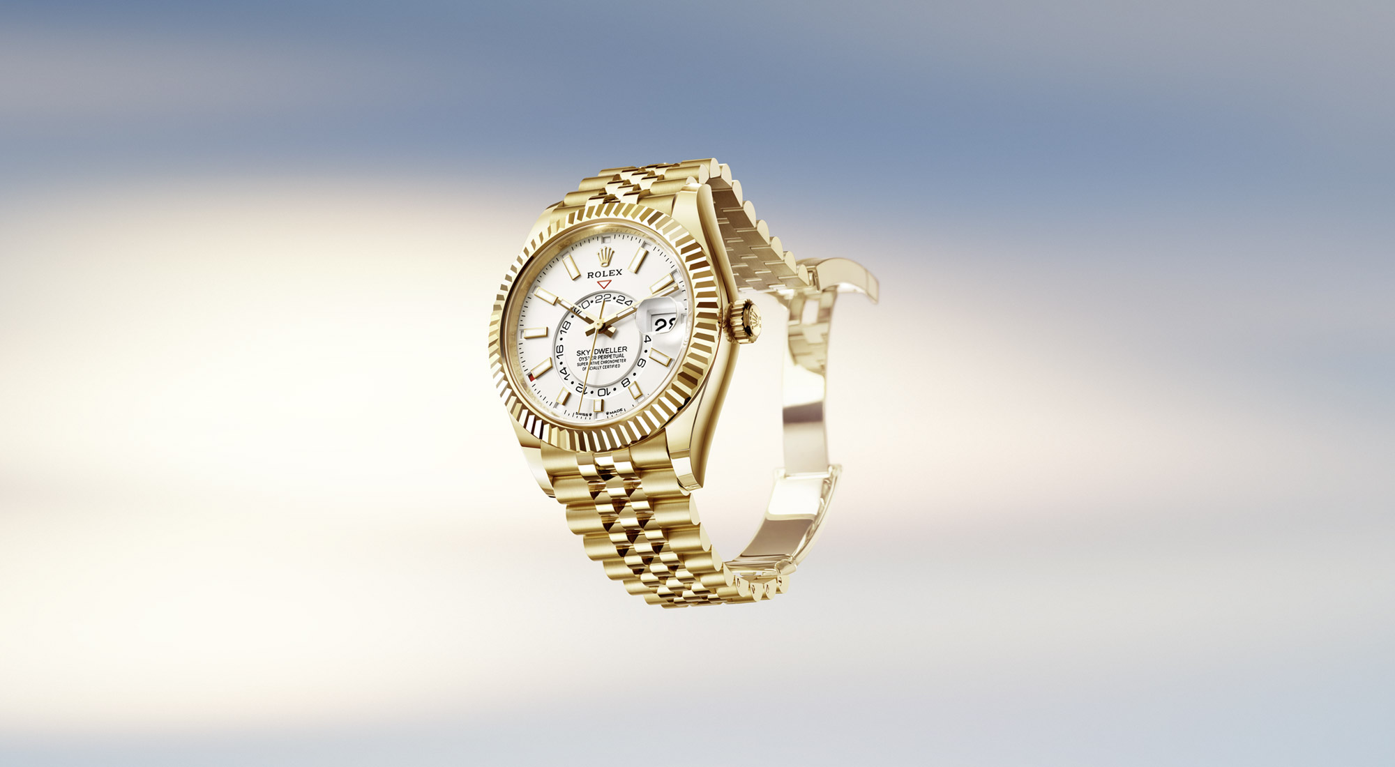 Rolex Sky-Dweller in Yellow Gold mit weißem Zifferblatt vor pastellfarbenem Himmel