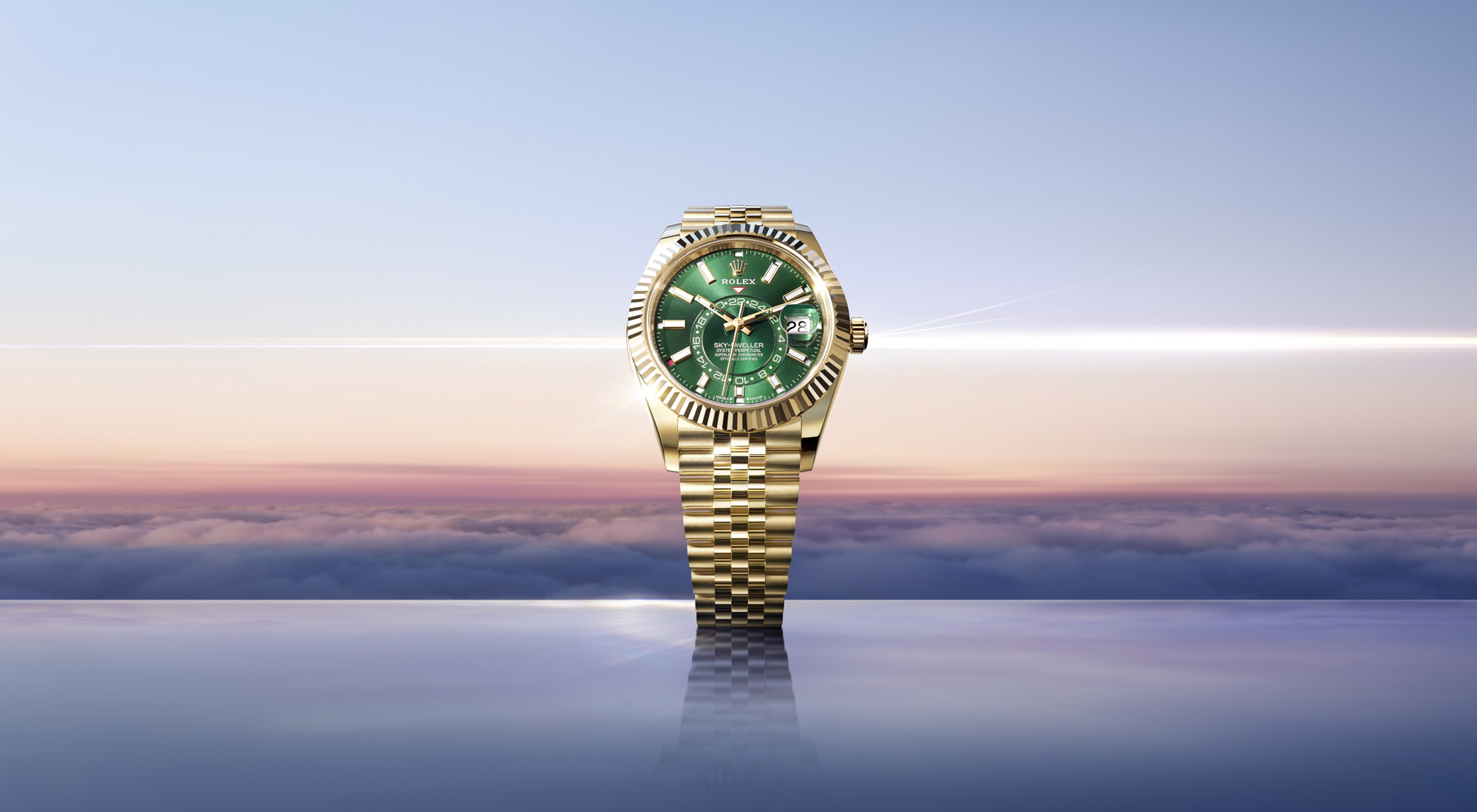 Rolex Sky-Dweller in Yellow Gold mit grünem Zifferblatt über den Wolken bei Sonnenaufgang