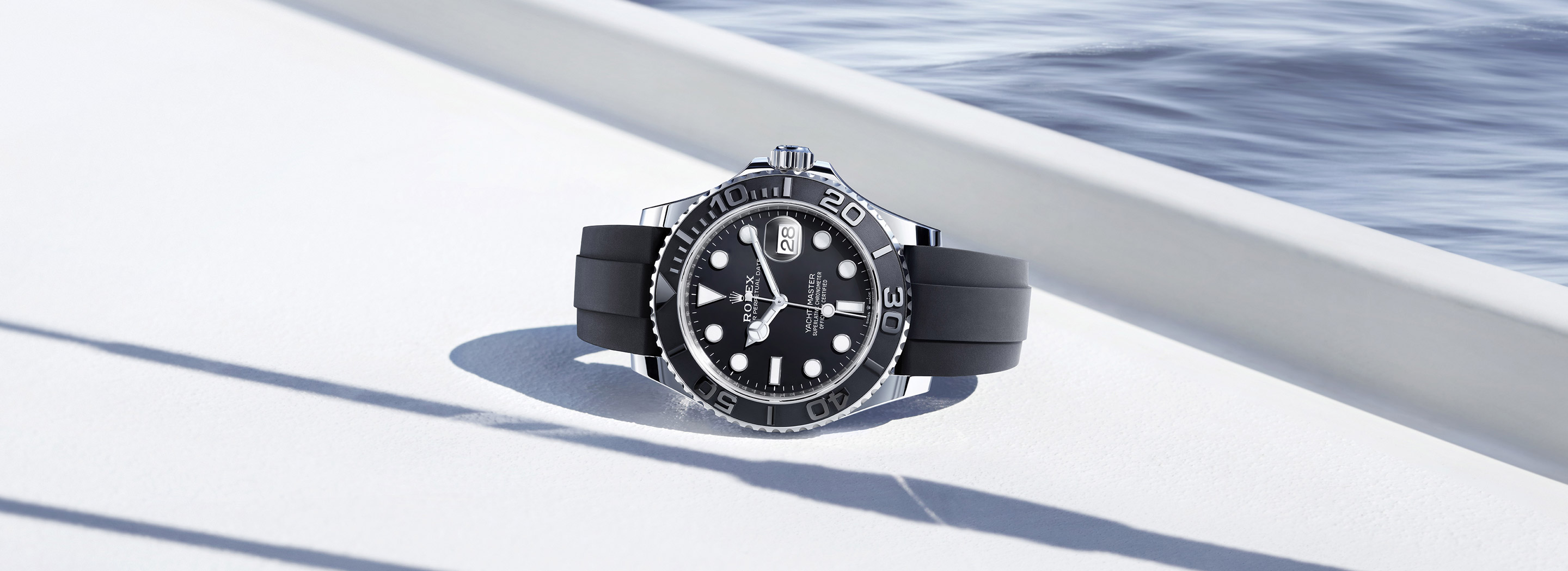 Rolex Yacht-Master 42 in Weißgold auf einer Yachtkante mit Wasser im Hintergrund