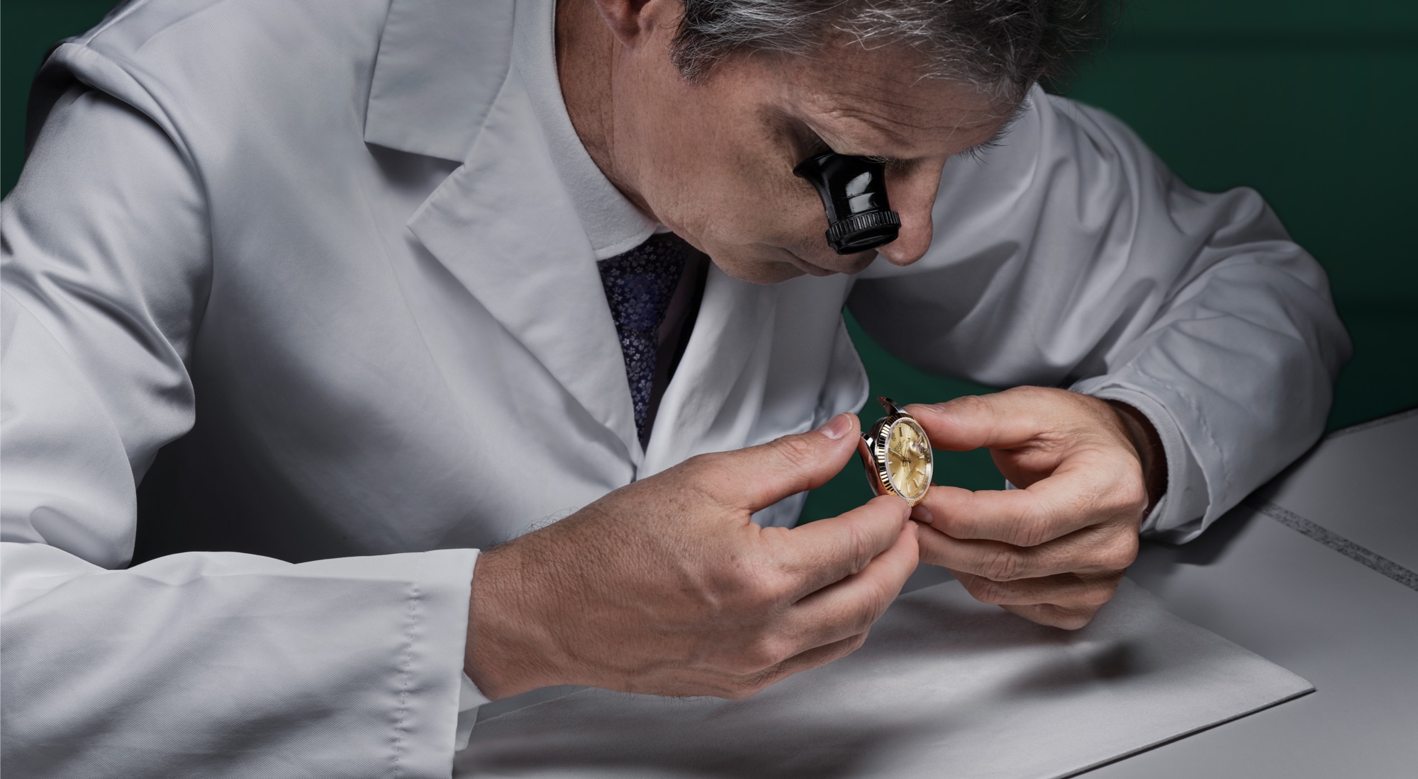 Rolex Uhrmacher inspiziert eine Vintage-Rolex mit Lupe