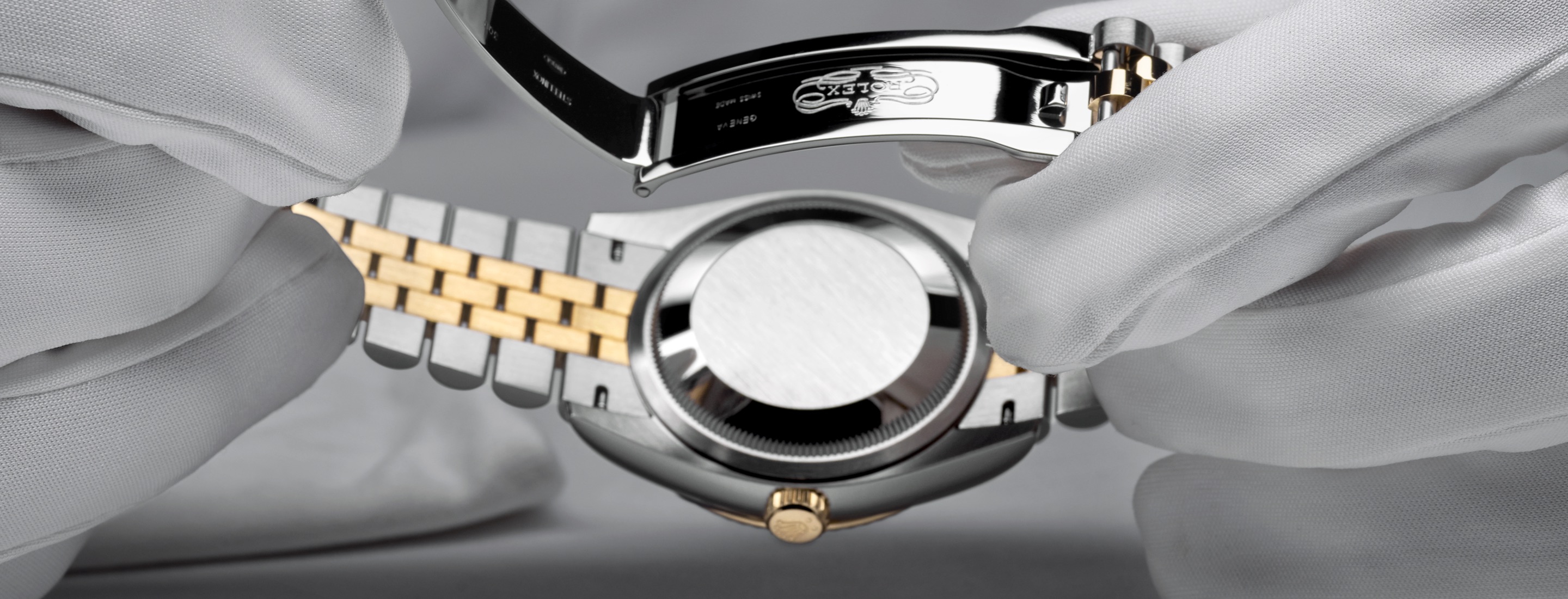 Weiße Handschuhe halten Datejust mit Gehäuseboden — Komplettservice